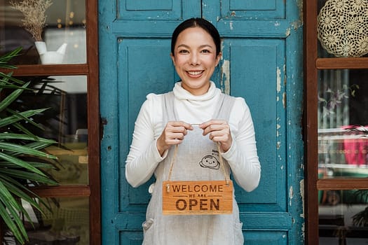 Simple Life Style 1: Apron-ed shop owner holding a welcome we are open sign. Photo by Ketut Subiyanto on Pexels.com
